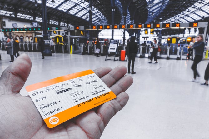 A person holiday a railway ticket at a major station