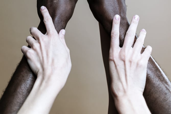 People holding hands and raising each other like a community.