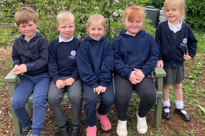 Farrington Gurney school children sitting on their new bench, thanks to Midsomer Norton Men’s Shed. 