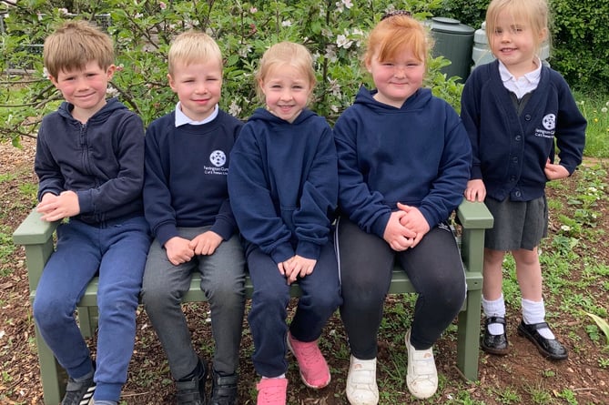 Farrington Gurney school children sitting on their new bench, thanks to Midsomer Norton Men’s Shed.