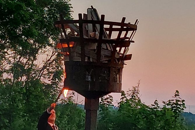 A photo of Ross Mayor Ed O’Driscoll lighting the beacon on The Prospect for the Queen’s platinum jubilee at sunset.