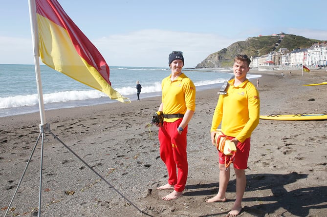 AB3005 RNLI198 PHOTO CODE 19DPJ30MAY198 - PHOTO DAVID ARWYN PARRY JONES / CAMBRIAN NEWS PRESS PHOTOGRAPHER - 30MAY2019 - REF Simon; RNLI lifeguards have returned to their posts across Wales from Saturday (25 May) to offer safety advice and assistance over the May half term. The charityâs lifeguards will be on the following beaches to welcome those enjoying the half term holidays on the Welsh coast: Ceredigion - Borth, Aberystwyth North, Llangrannog, New Quay Harbour, Aberporth. A lifeguarding service will be provided everyday between 10am-6pm over the school half term. The lifeguardâs role is to advise, supervise and rescue those in trouble on the beach or in the water. - PHOTO - Lifeguards Ellis Evans and Huw Jenkins at North Beach Aberystwyth Prom last Sunday.
