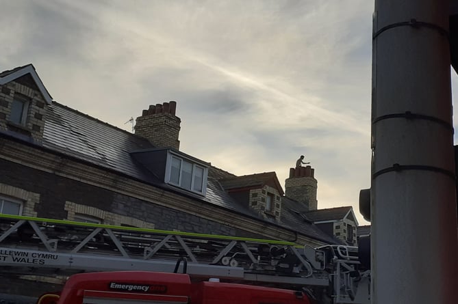 Person on roof Northgate Street, Aberystwyth, road closed