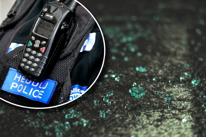 A police radio inset over broken glass from a car window