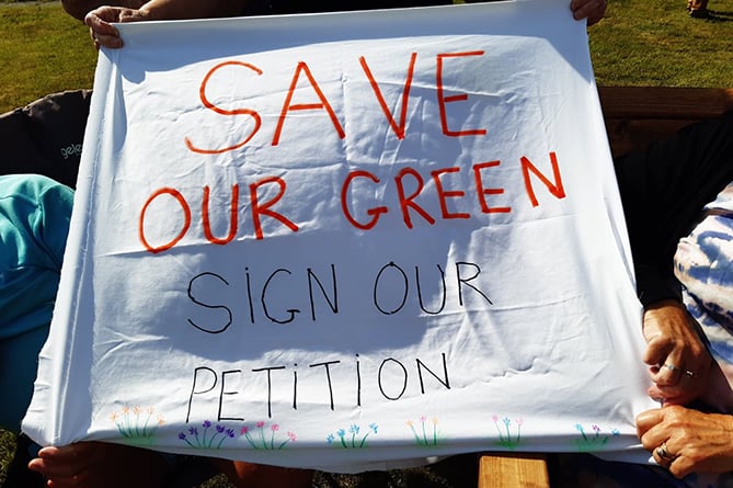 Residents made signs urging the community to sign their petition in a bid to stop a proposed housing development and save the green at Dol Hendre