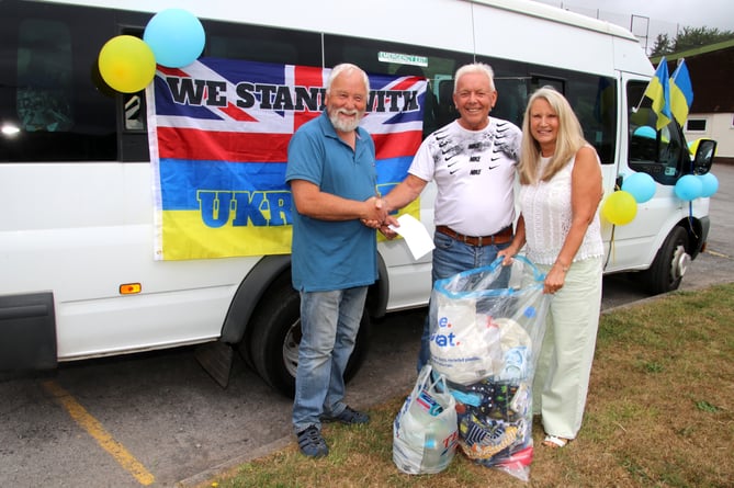 Joe, centre, receiving a cash donation towards his next trip with aid for refugees from Ukraine. AQ 7746